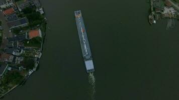 Aerial shot of barge sailing down the river in town video