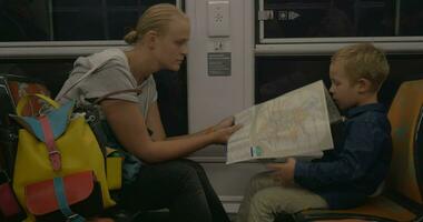 mãe e filho olhando às mapa dentro a trem video