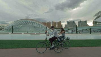 un Pareja montando bicicletas a lo largo el moderno Valencia ver video