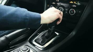 Female hand shifts gears. Automatic transmission, automatic gear shift, is moved from P to D. Park to Drive video
