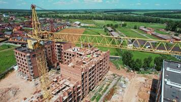 construcción de el casa con un grua y gente. grúas con lamparas en construcción sitio. 4k valores imágenes. video