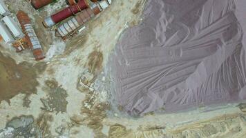 Arial view of the sand making plant in open-pit mining. Drone flies over excavators and tractor loading crushed stone and rock into dump truck. 4k stock footage. video