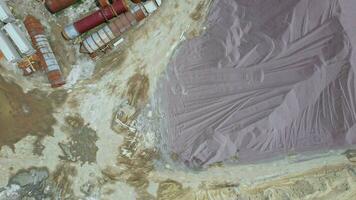 Arial view of the sand making plant in open-pit mining. Drone flies over excavators and tractor loading crushed stone and rock into dump truck. 4k stock footage. video