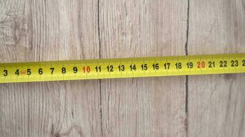 Measuring with yellow tape measure. Hands pull the measuring tape out of tape measure and measure the length. 4k stock footage. video