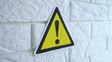 Electricity danger a sign on yellow background. A danger sign hangs on a wall. 4k stock footage. video