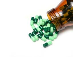 group of green capsule medicine in bottle photo