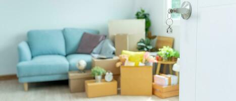 Moving house, relocation. The key was inserted into the door of the new house, inside the room was a cardboard box containing personal belongings and furniture. move in the apartment or condominium photo