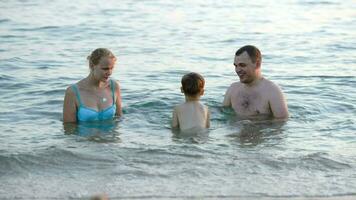 Parents and son playing ball in sea video