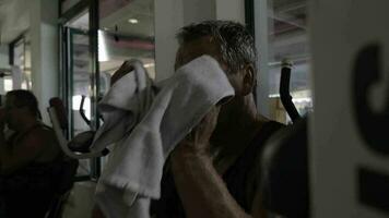 Tired man wiping sweat after workout in the gym video