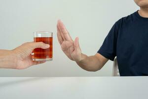 man refuses say no and avoid to drink an alcohol whiskey , stopping hand sign male, alcoholism treatment, alcohol addiction, quit booze, Stop Drinking Alcohol. Refuse Glass liquor, unhealthy, reject photo