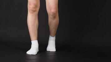 Asian Male split legs wear white sock is isolated on black background photo