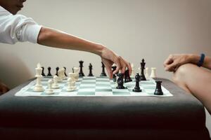 Young boy playing chess game with father at home. photo