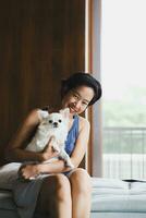 Vertical of woman beautiful holding a cute white small dog. photo