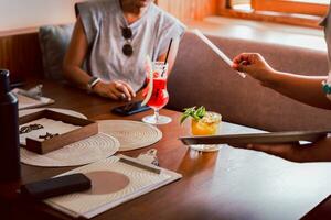 Waitress serving fresh passion fruit drink to customer in restaurant. photo