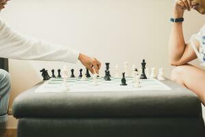 Young boy playing chess game with father at home. photo