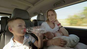 mamá con dos niños teniendo coche viaje video