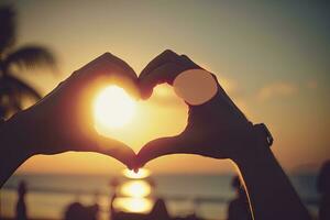 Tropical Sunrise Heart Shape Hands with Bokeh Sun Background photo