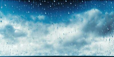 Raindrops on Glass with Beautiful Blue and White Sky Background photo