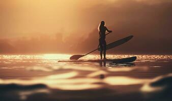 silueta de un hembra tablista remar en calma aguas a puesta de sol foto