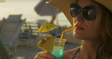 mujer en sombrero y Gafas de sol Bebiendo cóctel video