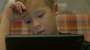 Boy spending leisure time with tablet PC video
