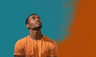 Man in Orange Shirt Thinking and Looking Up Against Blue Wall AI Generated photo