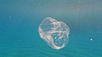 Ocean pollution - taking plastic bag from the sea video