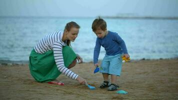 mor och son spelar på de strand video