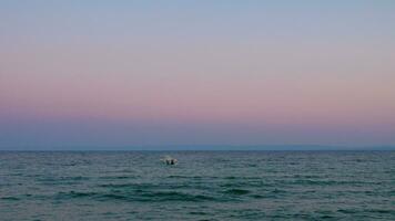 soir paysage aquatique avec solitaire bateau balancement sur mer vagues video