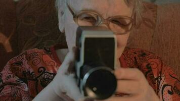 senior vrouw filmen met retro video camera