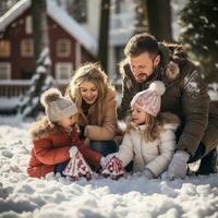 Happy family building snowman in front of their home photo