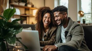 A Young Multiracial Couple Sitting on a Sofa at Home, Watching a Laptop photo