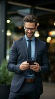 Successful businessman in suit holding smartphone and looking at screen photo