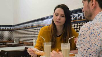 Mens en vrouw drinken horchata met fartons en churros video