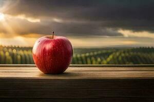 un rojo manzana se sienta en un de madera mesa en frente de un puesta de sol. generado por ai foto