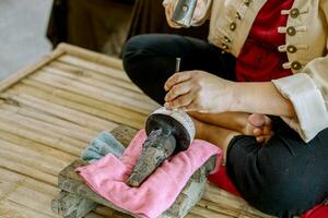 Closeup and crop Hands of Thailander demonstration of Carved silver water bowl at Chiang Mai, Thailand. photo