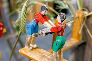 Closeup old and ancient wooden toy in humans play seesaw on blurred background. photo