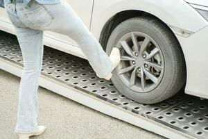 Woman's legs show fury after car breakdown on damage truck sliced. Car accident and broken concept. photo