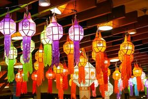 Closeup Colorful perspective view of Thai Lanna style lanterns to hanging on the ceiling and turn on light at night. photo