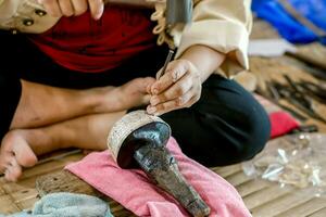 Closeup and crop Hands of Thailander demonstration of Carved silver water bowl at Chiang Mai, Thailand. photo