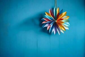 un vistoso origami flor colgando en un azul pared. generado por ai foto