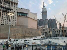 Mecca, Saudi Arabia, Sep 2023 - A beautiful view of the Makkah Royal Clock Tower at sunset. Pilgrims from all over the world are busy preparing for Maghrib prayers. photo