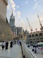 Mecca, Saudi Arabia, Sep 2023 - A beautiful view of the Makkah Royal Clock Tower at sunset. Pilgrims from all over the world are busy preparing for Maghrib prayers. photo