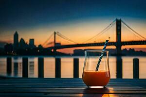 a glass of orange juice sits on a table with a bridge in the background. AI-Generated photo