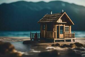 a miniature house on the beach with mountains in the background. AI-Generated photo
