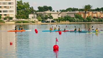 Athletes on kayaks swim while competing on the lake video