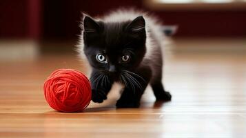 negro gatito en broma persiguiendo un rojo pelota de hilo en un madera dura piso. generativo ai foto