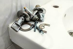 faulty ball valve and fixtures lie on edge of sink photo