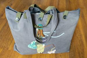 closed handcrafted gray fabric tote bag on floor photo