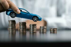 Blue Toy Car In Front Of Businessman Calculating Loan. Saving money for car concept, trade car for cash concept, finance concept. photo